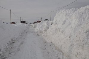 При въезде в Кузьминовку вдоль дороги высятся горы из снега
